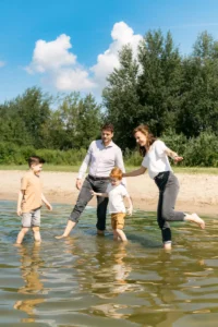 Vader, moeder en twee jongens staan op 1 been in het water